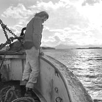 environment page: iconic photo of Greenpeace founder Robert Hunter aboard the Phyllis Cormack on the expedition to stop nuclear weapons testing at Amchitka Island