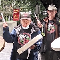 environment page: photo of Eddie Gardner and drummers from the Wild Salmon Defenders Alliance